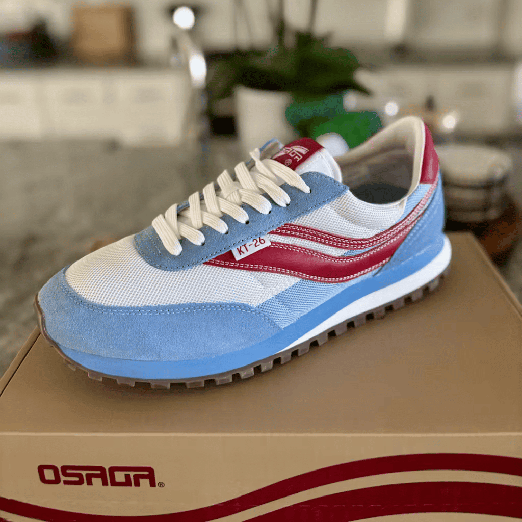 Blue and white sneaker with red accent stripes on a shoe box