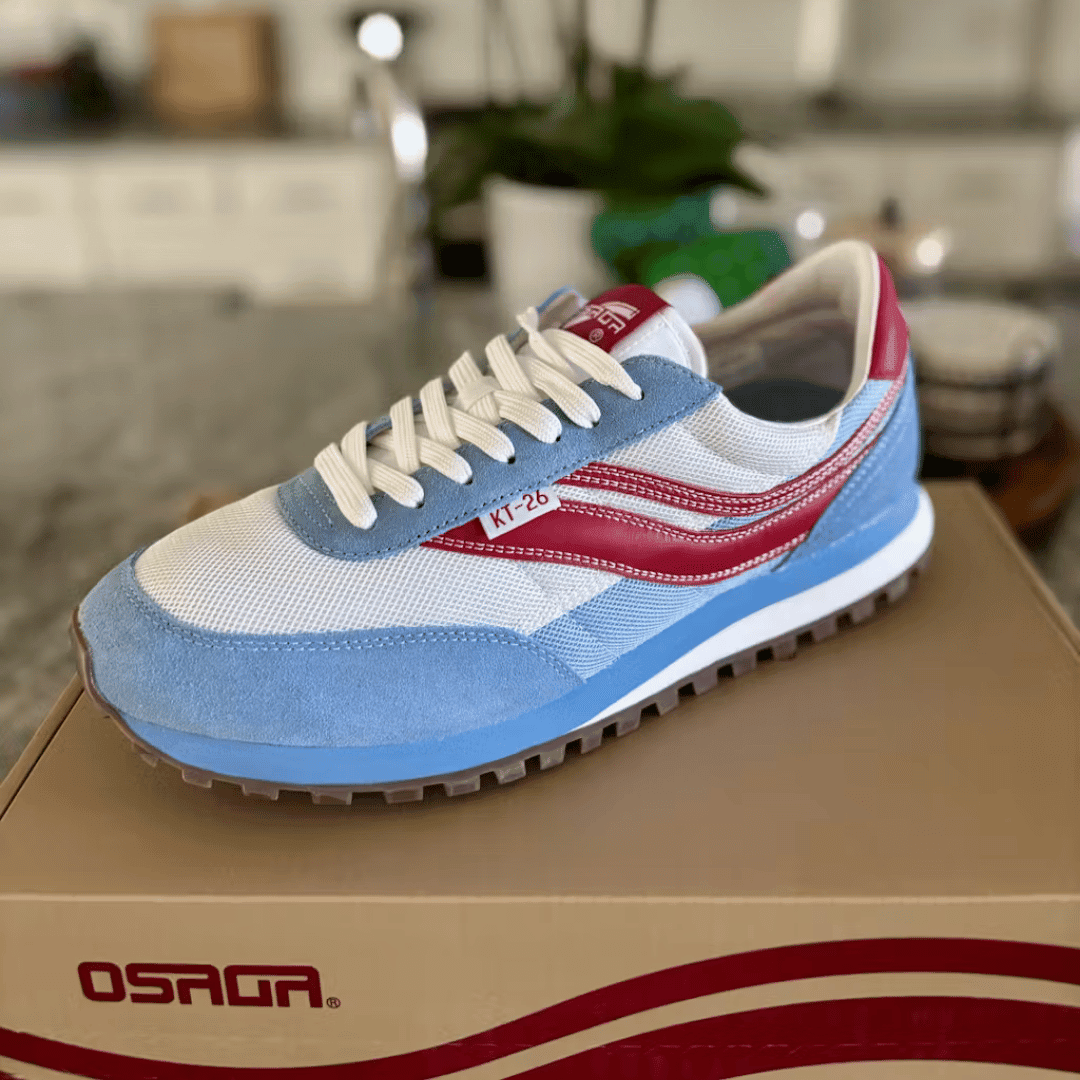 Blue and white sneaker with red accent stripes on a shoe box